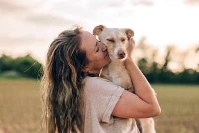 女性にハグされている犬