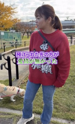 女性のそばで地面の匂いをかぐ犬