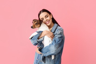 女性にハグされる犬