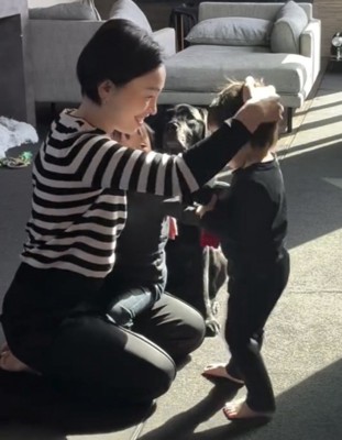 頭をなでられる男の子と見守る犬