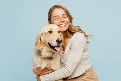 ゴールデンとハグをする女性