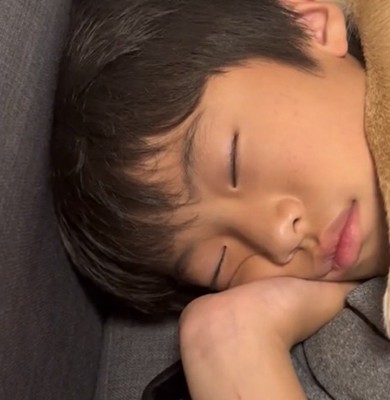 手を枕に眠る男の子