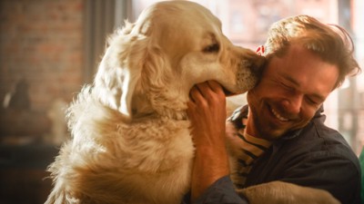 男性の頬を舐める犬