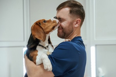 男性の顔を舐める犬