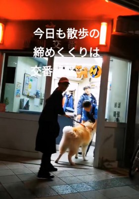 警察官に撫でてもらう秋田犬