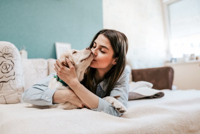 飼い主とベッドでリラックスする犬