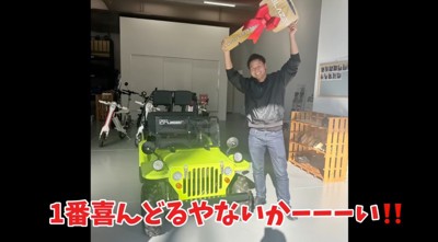 ミニカーの前で笑顔の男性