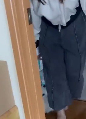 飼い主の後ろから部屋の中へ入る犬