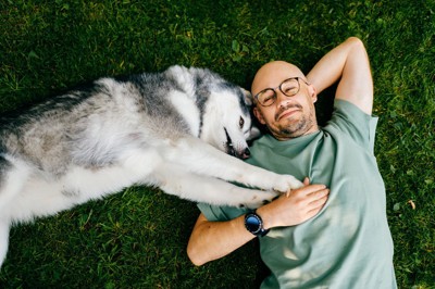 寝そべる男性と犬