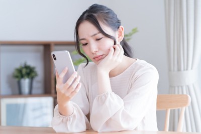 スマホ、頬杖をつく