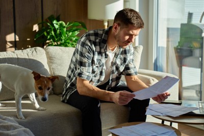 犬と明細を見る男性