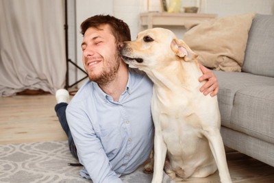 男性の耳のニオイを嗅ぐ犬