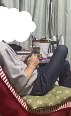 座椅子でスマホを操作する人