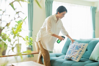 布製品にスプレーする女性