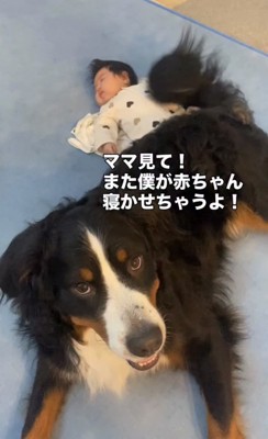 赤ちゃんのそばに伏せる犬