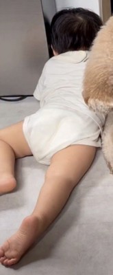 床にうつ伏せになる男の子
