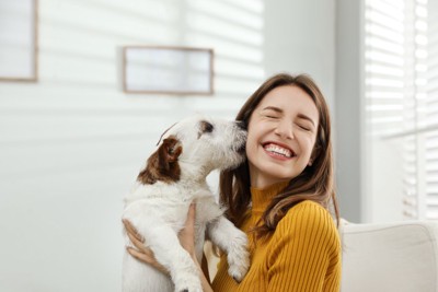 女性の顔を舐める犬