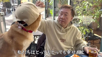 お父さんに帽子を被せてもらう犬