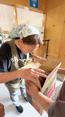 ダンボールの箱の中を見て声をあげる女将